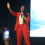 Shani Tené speaking in read suit